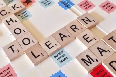 Fichas del juego "Scrabble" formando la palabra "Aprender", en una clase lúdica de inglés