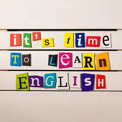Recortes de letras de colores forman la frase en inglés "Es hora de aprender inglés".